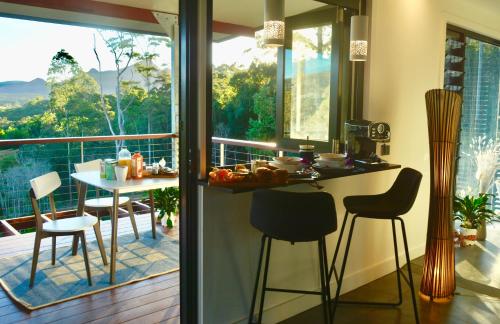 a kitchen with a balcony with a table and chairs at La Rochér Eco Retreat in Stokers Siding