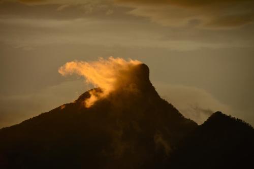a mountain with smoke coming out of it at sunset at La Rochér Eco Retreat in Stokers Siding