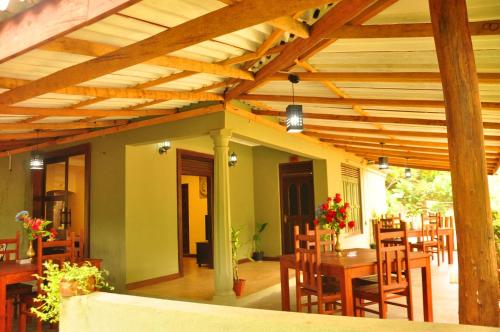 a patio with a wooden ceiling with a table and chairs at Thal Sewana in Sigiriya