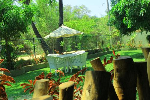 a patio with a table and an umbrella at Thal Sewana in Sigiriya