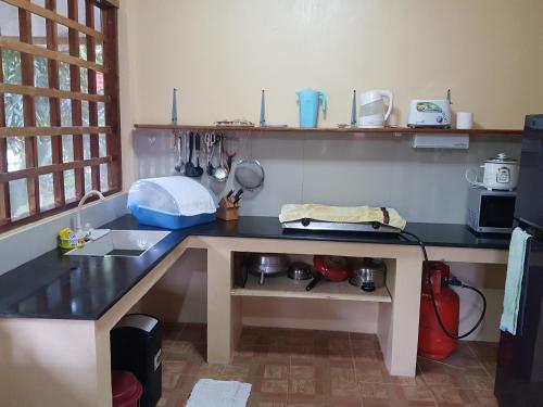 a kitchen with a black counter top and a table at Mountain View Cottages in Mambajao