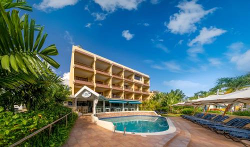 a resort with a swimming pool and a resort at Yellow Bird Hotel in Christ Church