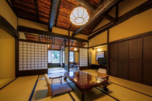 a living room with a table and chairs and a window at Shirakabe in Izu