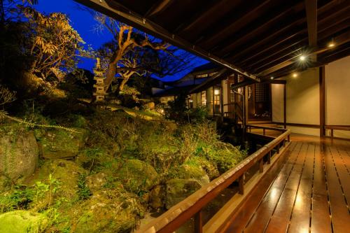 a house with a wooden deck and a garden at Shirakabe in Izu