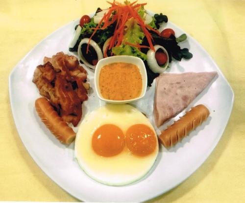 a plate of food with eggs meats and vegetables at VC@Suanpaak Boutique Hotel & Service Apartment in Chiang Mai