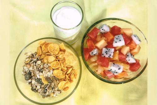 a table with two bowls of food and a glass of milk at VC@Suanpaak Boutique Hotel & Service Apartment in Chiang Mai