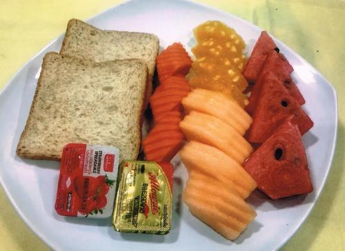 a plate of food with fruits and vegetables and bread at VC@Suanpaak Boutique Hotel & Service Apartment in Chiang Mai