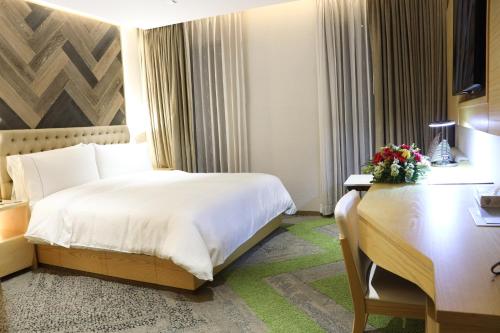 a hotel room with a large bed and a desk at HANSA- A Premium Residence in Dhaka