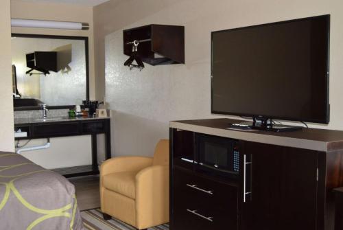 a room with a flat screen tv on a dresser at Super 8 by Wyndham Stockbridge in Stockbridge
