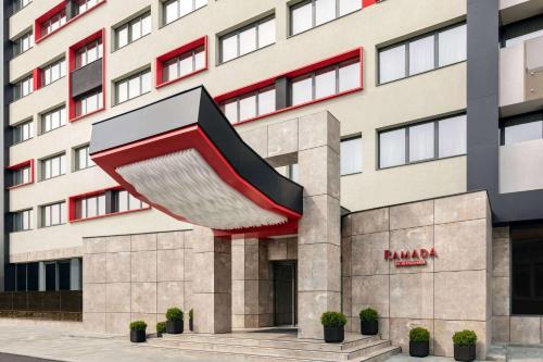 a building with a large red and white building at Ramada by Wyndham Ramnicu Valcea in Râmnicu Vâlcea