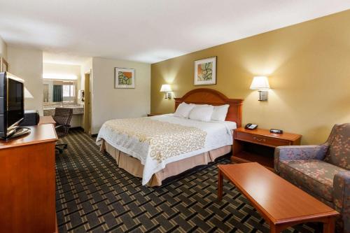 a hotel room with a bed and a couch at Days Inn by Wyndham Kent - Akron in Kent
