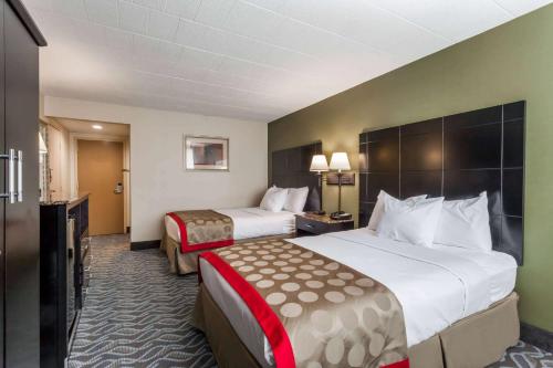 a hotel room with two beds and a television at Ramada by Wyndham Newburgh/West Point in Newburgh