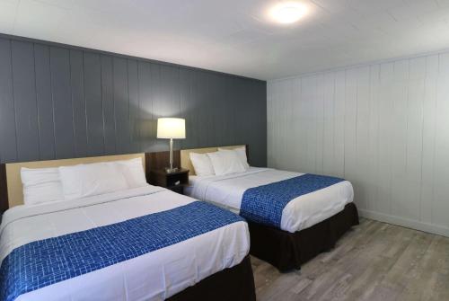 a hotel room with two beds and a lamp at Bishop Inn Downtown Gatlinburg in Gatlinburg