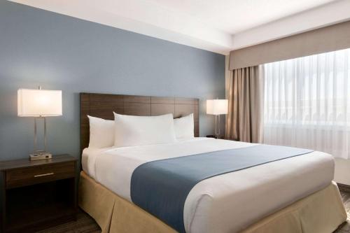 a large bed in a hotel room with two lamps at Travelodge Suites by Wyndham New Glasgow in New Glasgow