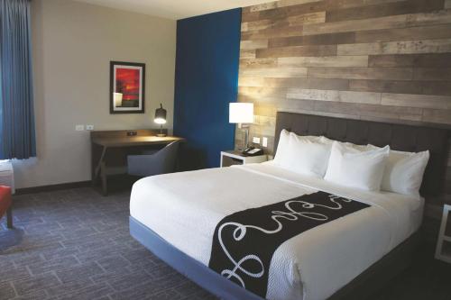 a hotel room with a large bed and a desk at La Quinta by Wyndham Pittsburg in Pittsburg