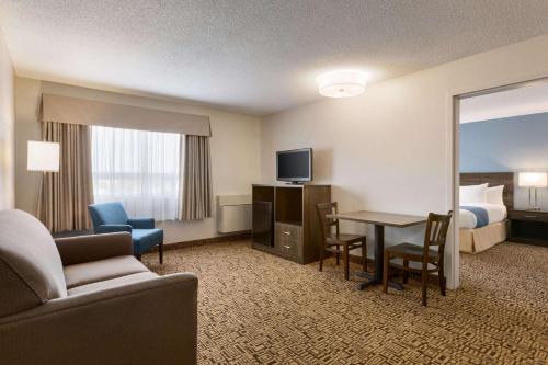 a hotel room with a couch and a table and a bed at Travelodge Suites by Wyndham New Glasgow in New Glasgow