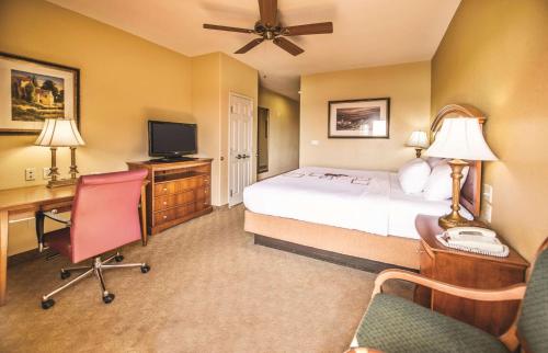 a hotel room with a bed and a desk with a telephone at La Quinta by Wyndham Marble Falls in Marble Falls
