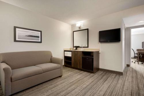a living room with a couch and a flat screen tv at Travelodge Suites by Wyndham New Glasgow in New Glasgow
