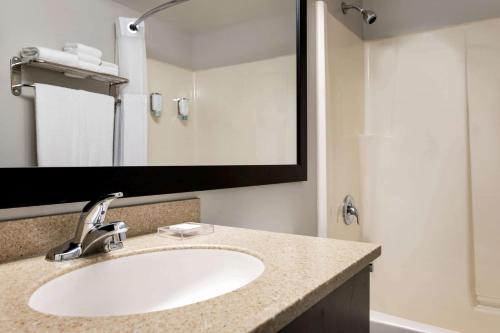 a bathroom with a sink and a mirror at Travelodge Suites by Wyndham New Glasgow in New Glasgow