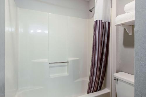 a bathroom with a shower curtain and a toilet at La Quinta Inn by Wyndham Ft. Lauderdale Tamarac East in Fort Lauderdale