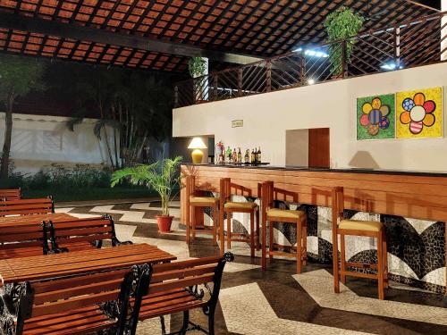 a bar in a restaurant with wooden benches at Novotel Goa Dona Sylvia Resort in Cavelossim