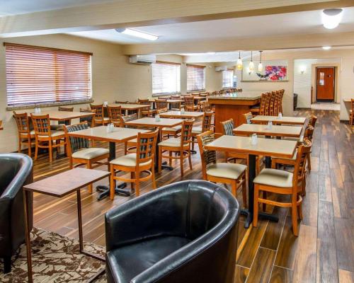 a restaurant with tables and chairs and a bar at Quality Inn Oakwood in Spokane