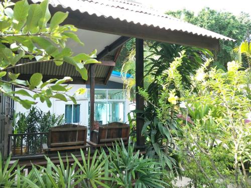 a house with two benches in front of it at BeauBo Beach in Baan Tai