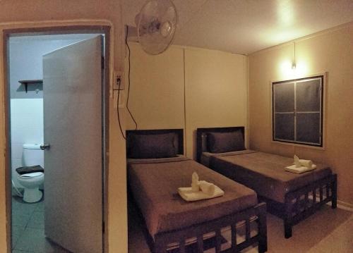 a small room with two beds and a toilet at BeauBo Beach in Baan Tai