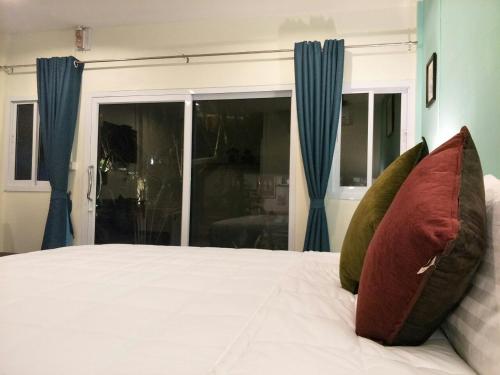 a bedroom with a bed with two pillows on it at BeauBo Beach in Baan Tai