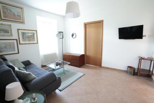 a living room with a couch and a tv at Quater Apartments - Tremezzina in Mezzegra