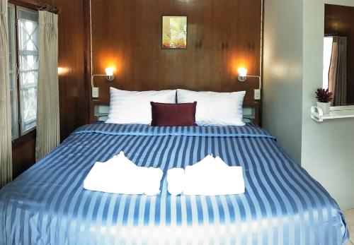 a bedroom with a blue and white bed with two pillows at BeauBo Beach in Baan Tai