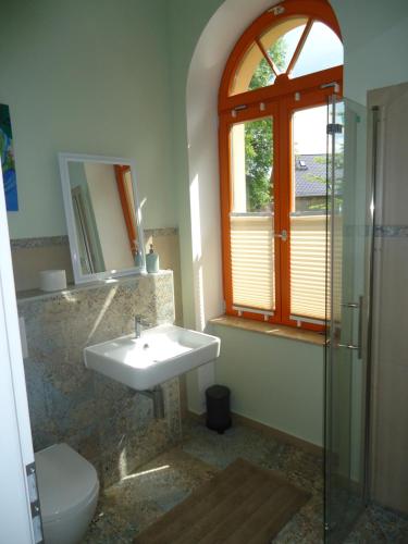 een badkamer met een wastafel, een toilet en een raam bij Ferienwohnung Gänseblümchen in Buchholz in Buchholz