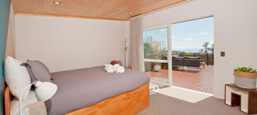 a bedroom with a bed and a balcony at Nelson City Escape in Nelson