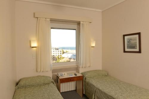 Un pat sau paturi într-o cameră la Comodoro Hotel