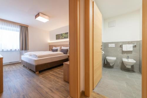 a bedroom with a bed and a sink and a toilet at Residence Lersc in Badia