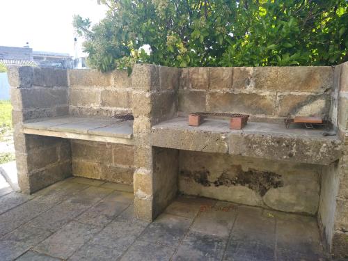 two stone benches sitting on a brick wall at B&B Terra Serena in Santa Cesarea Terme