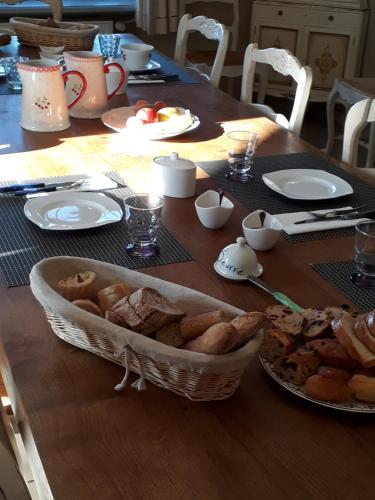 a table with a basket of bread on top of it at Maison d'hôtes La Tuilerie in Peschadoires