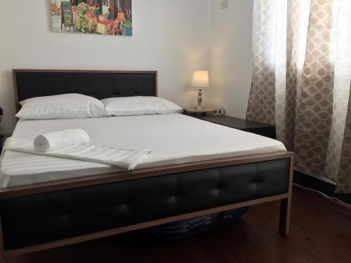 - un lit avec des draps et des oreillers blancs dans l'établissement Condo eLgimikero, à Manille