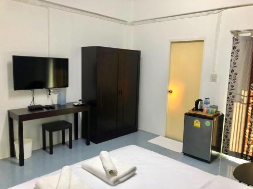 a room with a tv and a desk and a bed at Oblique Apartment - ออฟบลิค อพาร์ทเมนท์ in Nonthaburi