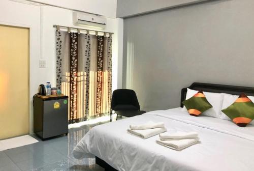 a bedroom with a bed with a chair and a window at Oblique Apartment - ออฟบลิค อพาร์ทเมนท์ in Nonthaburi