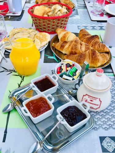 een dienblad met brood, jam en jus d'orange bij Les 3 Tilleuls in Roye