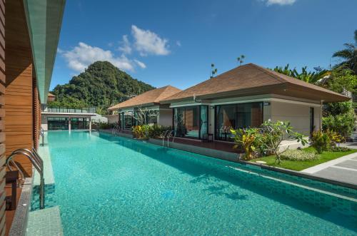 a swimming pool in front of a house at Cher​mantra​ Aonang​ Resort & Pool​ Suite in Ao Nang Beach