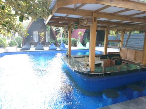 una piscina con una barca in acqua di Coral Beach 2 Bungalow a Gili Trawangan