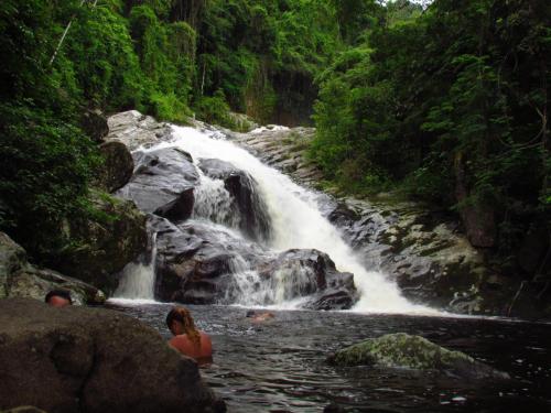 two people swimming in a waterfall in a river at Pousada Quatro Estações Paraty in Sertão do Taquari