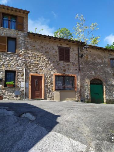 a stone house with two doors and a driveway at Casetta degli Etruschi ALLOGGIO TURISTICO in Allumiere