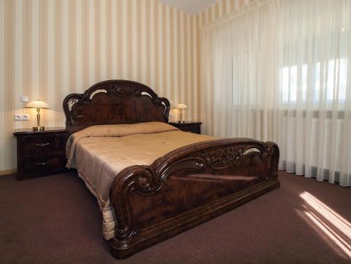a bedroom with a large wooden bed and a window at Vila Levita in Palanga