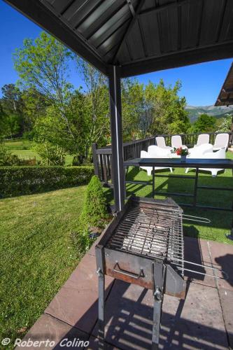 a picnic table and white chairs on a patio at Artesoro Baserria in San Pedro de Galdames