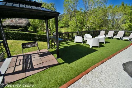 a lawn with chairs and a gazebo at Artesoro Baserria in San Pedro de Galdames