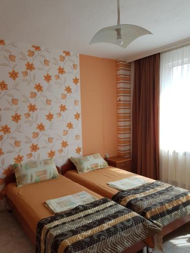 ポモリエにあるFimo Apartamentsのベッドルーム1室(ベッド2台付)、花の壁が備わります。