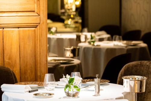 une salle à manger avec des tables et des nappes blanches dans l'établissement Grand Hôtel du Lion d'Or, à Romorantin-Lanthenay